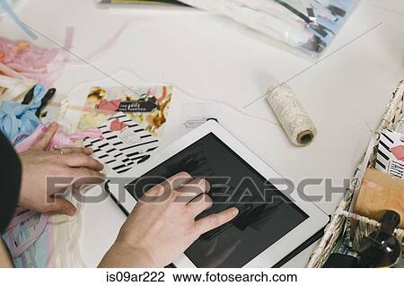 Stock Image - Close up female designers hands using digital tablet in design studio. Fotosearch