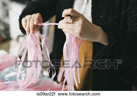 Close up of female textile designer twirling ribbons together in design studio View Large Photo Image Stock Image - Close up of female textile designer twirling ribbons together in design studio. Fotosearch