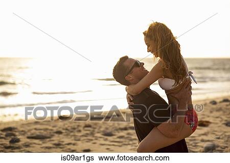 Stock Photograph - "Couple having fun on beach, Malibu, California, USA". Fotosearch