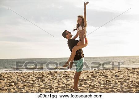 Stock Photography - "Couple having fun on beach, Malibu, California, USA". Fotosearch