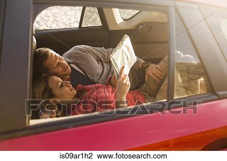 Stock Image - Couple reading map inside vehicle. Fotosearch