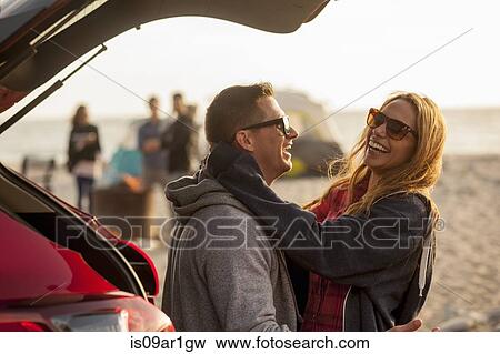 Couple relaxing behind vehicle on beach View Large Photo Image Stock Photo - Couple relaxing behind vehicle on beach. Fotosearch