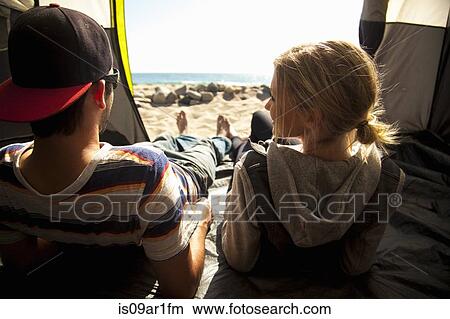 Picture - "Couple relaxing inside tent on beach, Malibu, California, USA". Fotosearch