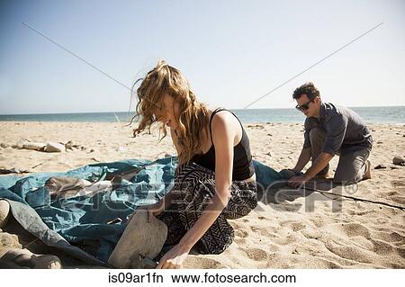 "Couple setting up tent on beach, Malibu, California, USA" View Large Photo Image Picture - "Couple setting up tent on beach, Malibu, California, USA". Fotosearch