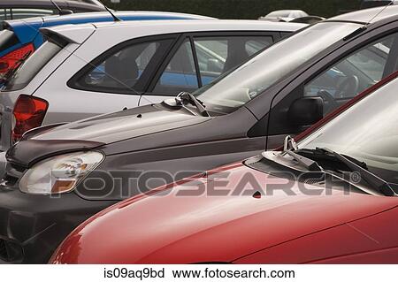 Cropped row of small cars in parking lot View Large Photo Image Stock Image - Cropped row of small cars in parking lot. Fotosearch