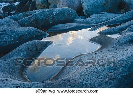 Stock Image - Detail of rock pool and blue sky reflection. Fotosearch
