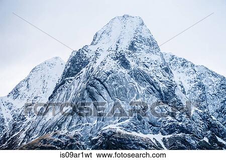 Stock Photograph - "Detail view of snow capped mountain, Reine, Lofoten, Norway". Fotosearch