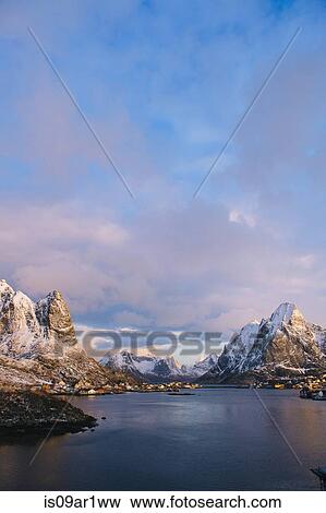 "Distant view of waterfront village and snow capped mountains at dusk, Reine, Lofoten, Norway" View Large Photo Image Stock Photo - "Distant view of waterfront village and snow capped mountains at dusk, Reine, Lofoten, Norway". Fotosearch