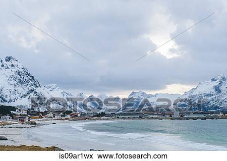 "Distant view of waterfront village and snow capped mountains, Reine, Lofoten, Norway" View Large Photo Image Stock Photo - "Distant view of waterfront village and snow capped mountains, Reine, Lofoten, Norway". Fotosearch