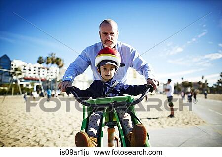 "Father guiding son on bicycle at beach, Brooklyn, New York, USA" View Large Photo Image Stock Photograph - "Father guiding son on bicycle at beach, Brooklyn, New York, USA". Fotosearch