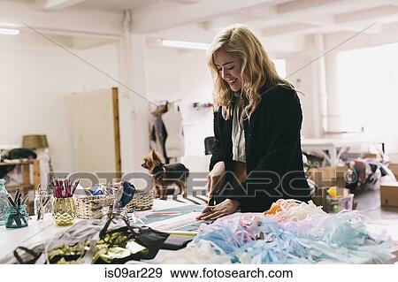 Female textile designer cutting textiles in design studio View Large Photo Image Stock Photo - Female textile designer cutting textiles in design studio. Fotosearch