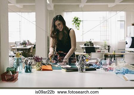 Stock Image - Female textile designer preparing textiles in design studio. Fotosearch