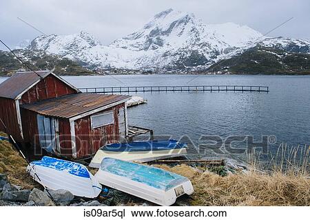 Stock Image - "Fishing hut and upturned boats, Reine, Lofoten, Norway". Fotosearch