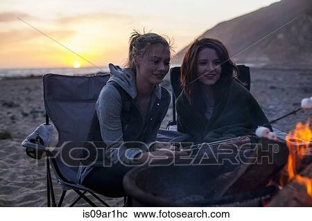 Stock Image - "Girlfriends having barbecue on beach, Malibu, California, USA". Fotosearch