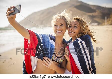 Stock Photo - "Girlfriends taking selfie on beach, Malibu, California, USA". Fotosearch
