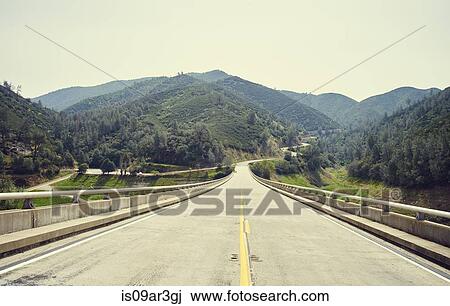 Stock Image - "Golden chain highway over Lake McClure Bagby, route 49, Mariposa county, California, USA". Fotosearch