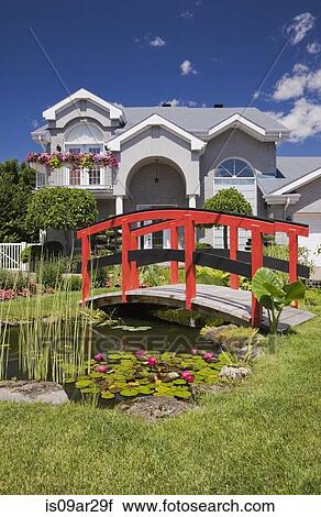 "Grey brick cottage style residential home and landscaped manicured garden with red wooden footbridge, Quebec, Canada" View Large Photo Image Stock Image - "Grey brick cottage style residential home and landscaped manicured garden with red wooden footbridge, Quebec, Canada". Fotosearch