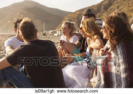 Stock Image - "Group of friends camping on beach, Malibu, California, USA". Fotosearch