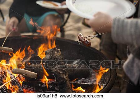 Stock Photo - Group of friends having barbecue on beach. Fotosearch