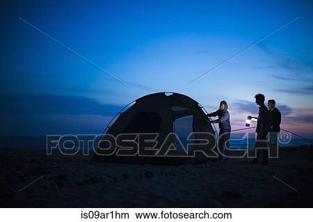 Group of friends setting up tent on beach at sunset View Large Photo Image Picture - Group of friends setting up tent on beach at sunset. Fotosearch