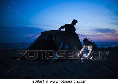 Group of friends setting up tent on beach at sunset View Large Photo Image Stock Image - Group of friends setting up tent on beach at sunset. Fotosearch