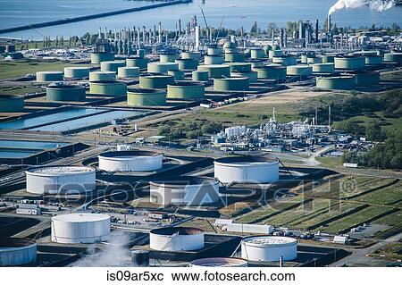 Stock Image - High angle view of oil storage tanks in coastal oil refinery. Fotosearch