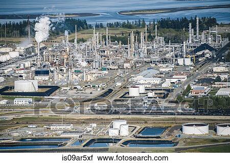 High angle view of oil storage tanks and smoke stack in coastal oil refinery View Large Photo Image Stock Image - High angle view of oil storage tanks and smoke stack in coastal oil refinery. Fotosearch