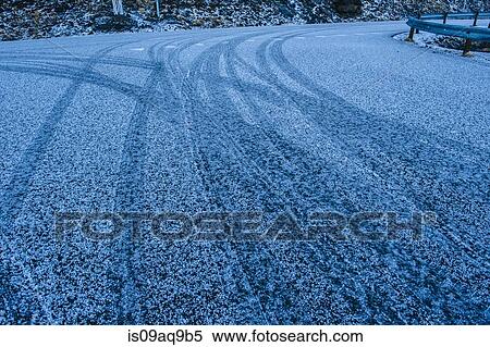 Stock Photography - "Low angle view of tire tracks on snowy highway, Reine, Lofoten, Norway". Fotosearch