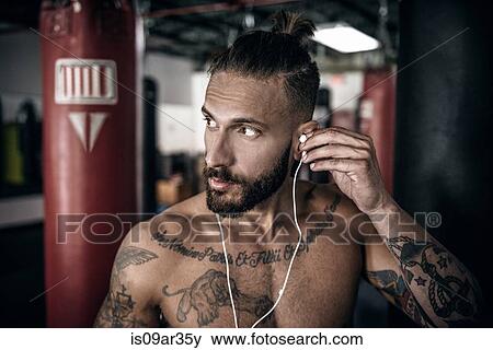 Male boxer inserting ear phones in preparation for training View Large Photo Image Stock Photo - Male boxer inserting ear phones in preparation for training. Fotosearch