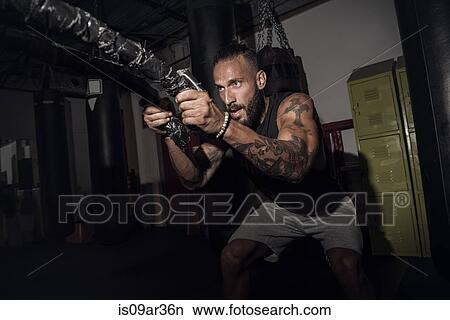 Male boxer pulling battle rope in gym View Large Photo Image Picture - Male boxer pulling battle rope in gym. Fotosearch