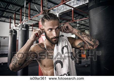 Male boxer putting in earphones at gym View Large Photo Image Stock Image - Male boxer putting in earphones at gym. Fotosearch