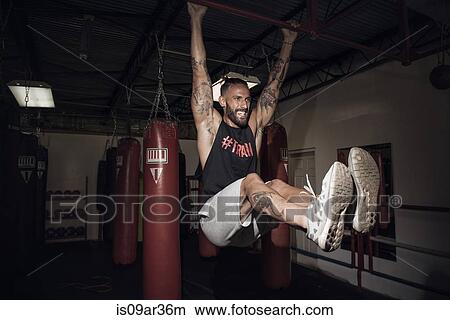 Male boxer training on bar with gritted teeth in gym View Large Photo Image Picture - Male boxer training on bar with gritted teeth in gym. Fotosearch