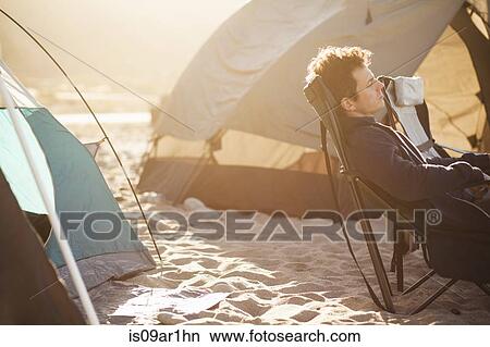 Picture - "Man at beach camp, Malibu, California, USA". Fotosearch
