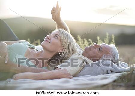 Mature couple lying on blanket looking up View Large Photo Image Stock Image - Mature couple lying on blanket looking up. Fotosearch