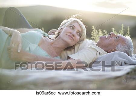 Mature couple lying together on blanket outdoors View Large Photo Image Stock Image - Mature couple lying together on blanket outdoors. Fotosearch