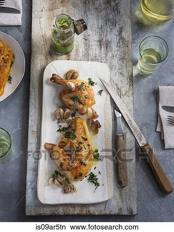 Picture - Overhead view of roasted chicken with herb garnish. Fotosearch