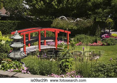 Stock Image - "Pagoda and red and black footbridge over pond with in landscaped garden, Quebec, Canada". Fotosearch