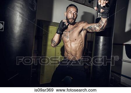 Poised male boxer with bandaged hands in gym View Large Photo Image Stock Photo - Poised male boxer with bandaged hands in gym. Fotosearch