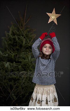 Portrait of a girl holding a christmas decoration View Large Photo Image Stock Photo - Portrait of a girl holding a christmas decoration. Fotosearch
