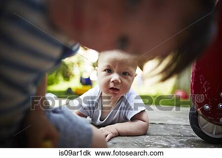 Portrait of baby boy lying down looking at camera with older brother in foreground View Large Photo Image Stock Image - Portrait of baby boy lying down looking at camera with older brother in foreground. Fotosearch