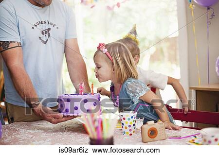 Portrait of blonde girl blowing out candles on purple cake View Large Photo Image Stock Photo - Portrait of blonde girl blowing out candles on purple cake. Fotosearch