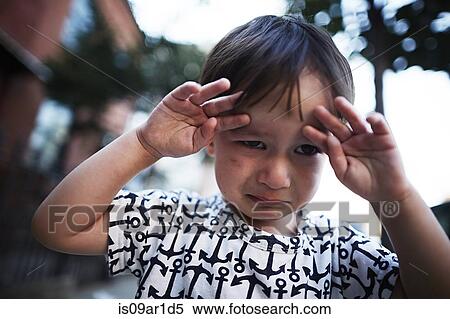 Stock Photography - Portrait of boy crying on street. Fotosearch