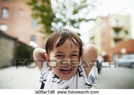 Stock Photo - Portrait of laughing boy with his hands behind his head. Fotosearch