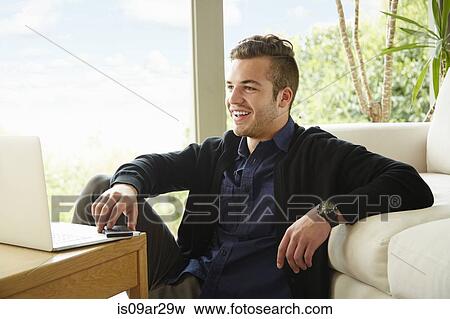 Portrait of smiling man sitting on floor holding smartphone View Large Photo Image Stock Photo - Portrait of smiling man sitting on floor holding smartphone. Fotosearch