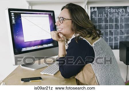 Portrait of young female office worker daydreaming at desk View Large Photo Image Stock Photo - Portrait of young female office worker daydreaming at desk. Fotosearch