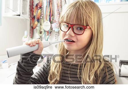 Portrait of young girl brushing teeth View Large Photo Image Stock Image - Portrait of young girl brushing teeth. Fotosearch