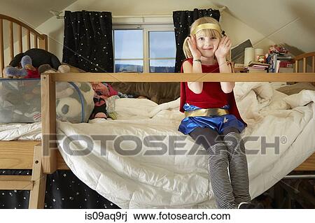 Portrait Of Young Girl Sitting On Bed Wearing Fancy Dress