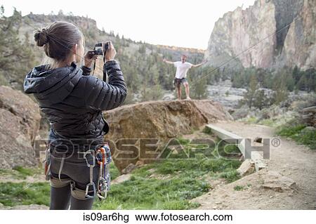 Stock Image - "Rock climber taking photograph, Smith Rock State Park, Oregon". Fotosearch