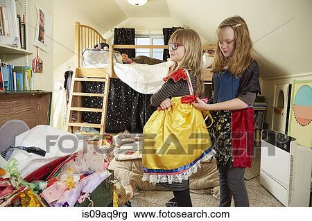 "Two sisters playing dress up, One helping the other fasten dress" View Large Photo Image Stock Image - "Two sisters playing dress up, One helping the other fasten dress". Fotosearch