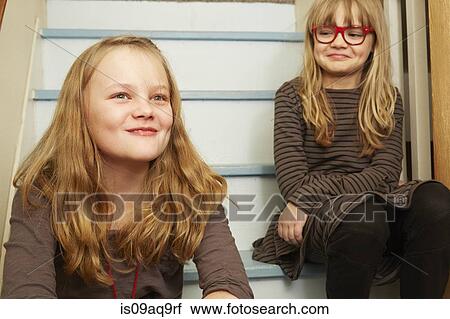 "Two sisters sitting on stairs, smiling" View Large Photo Image Stock Image - "Two sisters sitting on stairs, smiling". Fotosearch